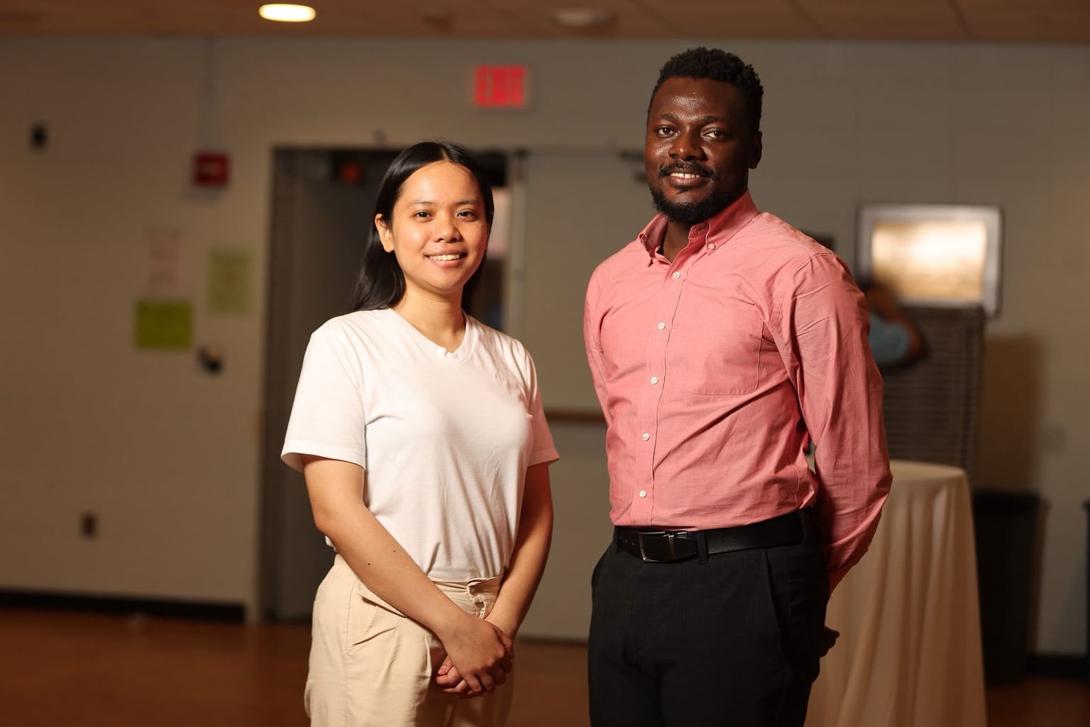 Terrick standing with a student in an event hall